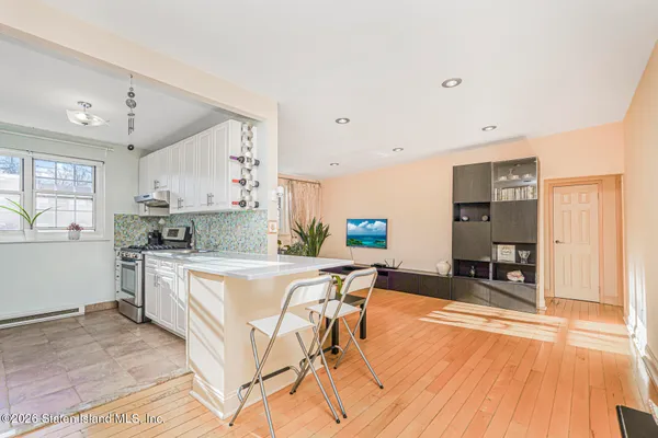 a kitchen with stainless steel appliances granite countertop a stove a sink dishwasher and a refrigerator with wooden floor