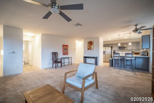 a living room with furniture and kitchen view