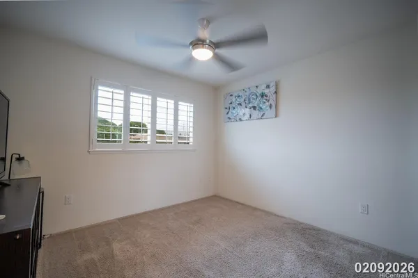 an empty room with windows and ceiling fan