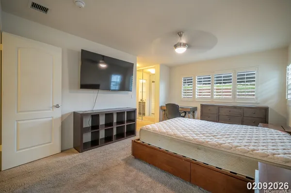 a spacious bedroom with a bed and a flat screen tv