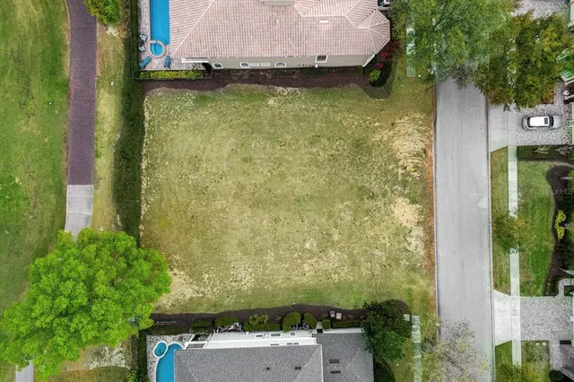 an aerial view of a house with a yard large trees