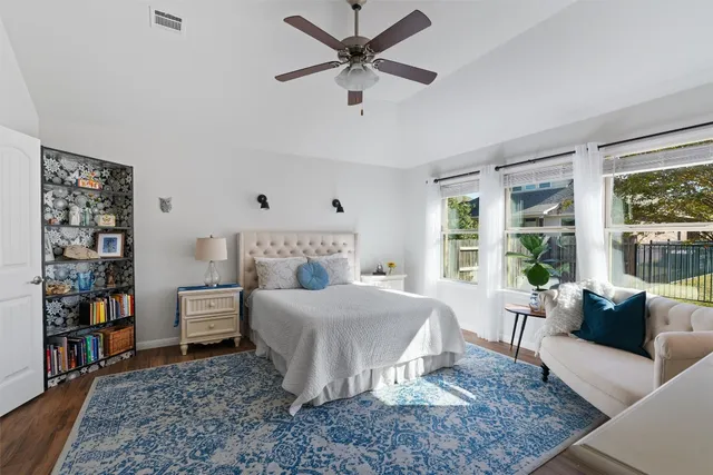 a bedroom with a bed a bookshelf and a large window