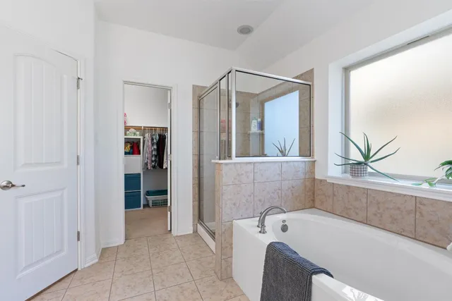 a bathroom with a tub a sink and a mirror