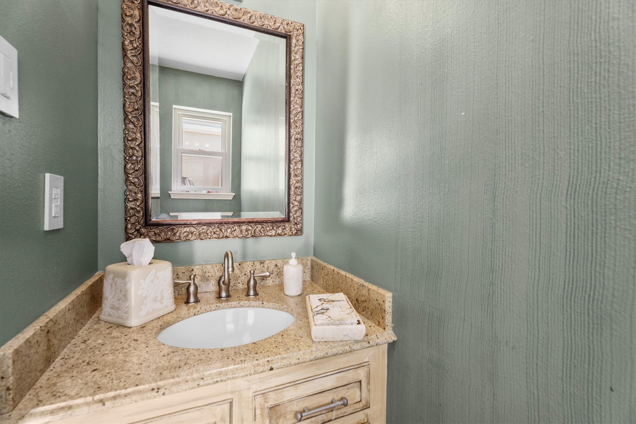 9103 Herts Road Spring, TX 77379 - Photo 20 of 46 A beautiful half bath, through a pocket door, offers a touch of elegance with a warm vanity and beautiful blue green walls.