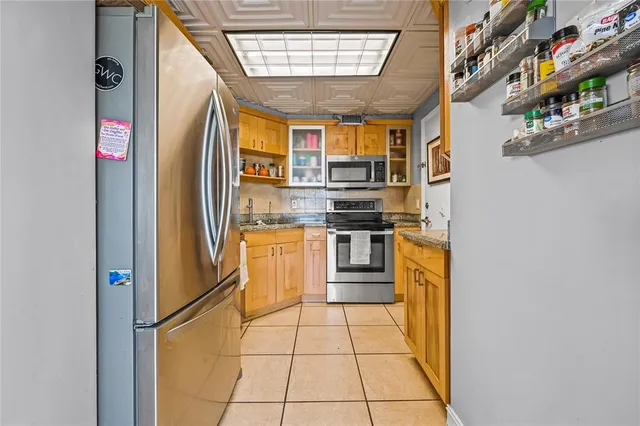 a kitchen with stainless steel appliances granite countertop a refrigerator and a sink