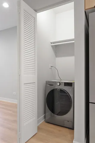 a utility room with washing machine and a window