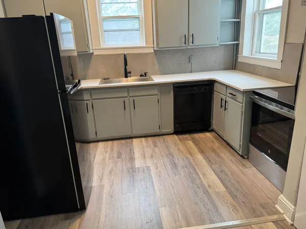 a kitchen with a sink a refrigerator and window