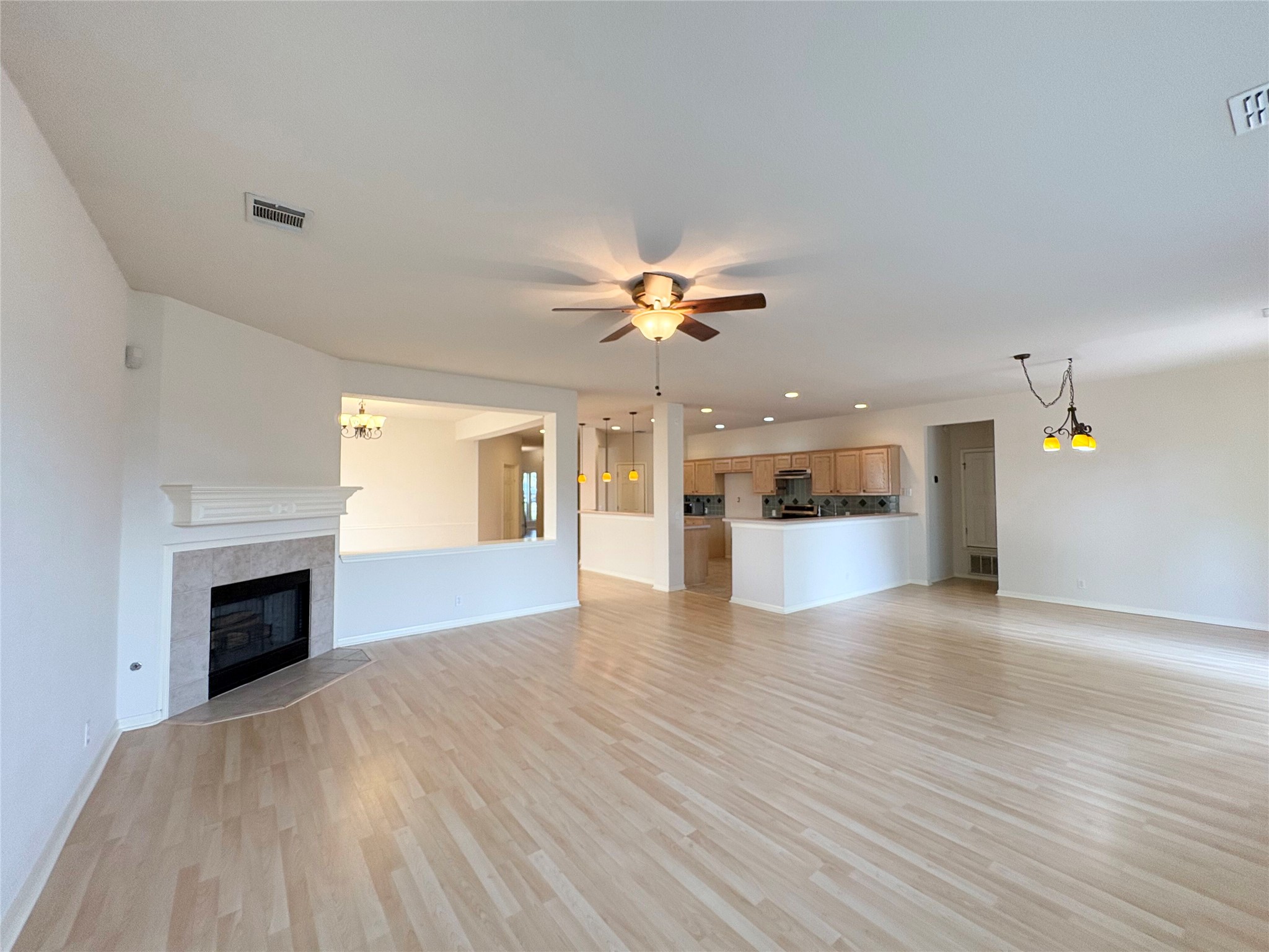 7006 Rambollet Terrace Round Rock, TX 78681 - Photo 38 of 38 An open floorplan seamlessly connects living spaces, featuring gleaming hardwood floors and a cozy corner fireplace.