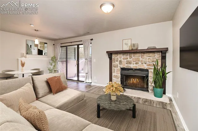an empty room with wooden floor fireplace and windows