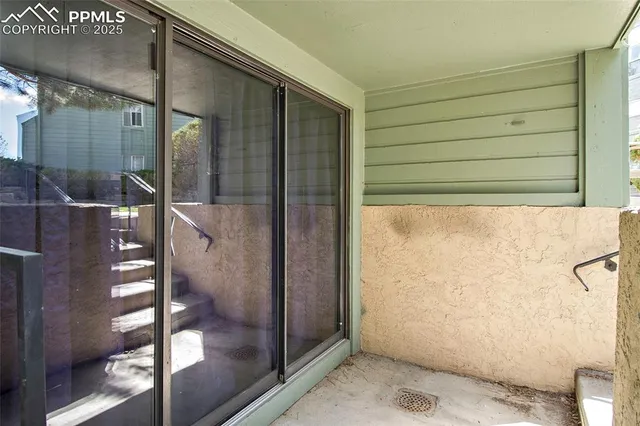 a view of a patio with a table and chairs under an umbrella