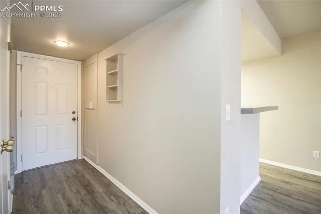a view of an empty room with wooden floor