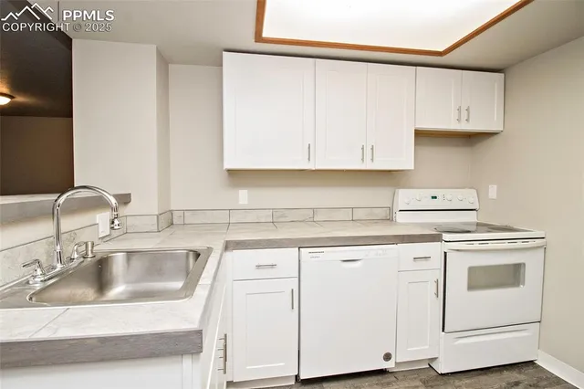 a kitchen with cabinets appliances a sink and a counter top