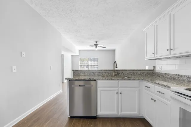a kitchen with granite countertop a sink and cabinets