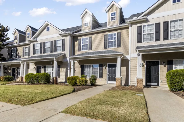 front view of a brick house with a yard