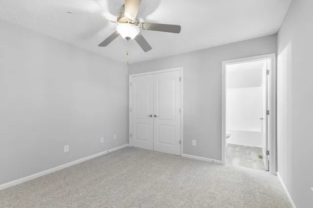 an empty room with a ceiling fan and a window