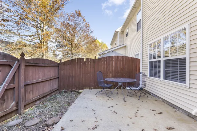 a view of a backyard with a large tree and wooden fence
