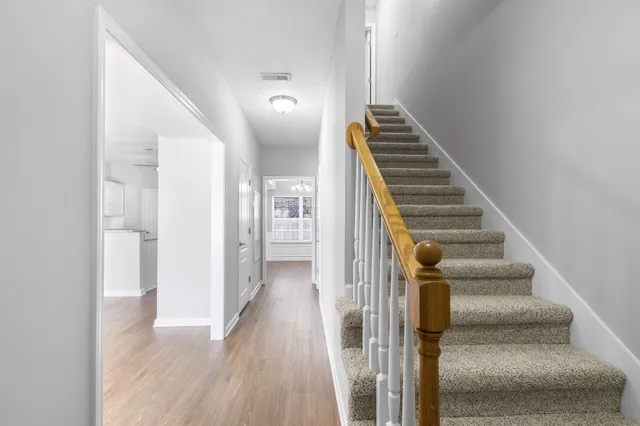 a view of hallway with stairs and wooden floor