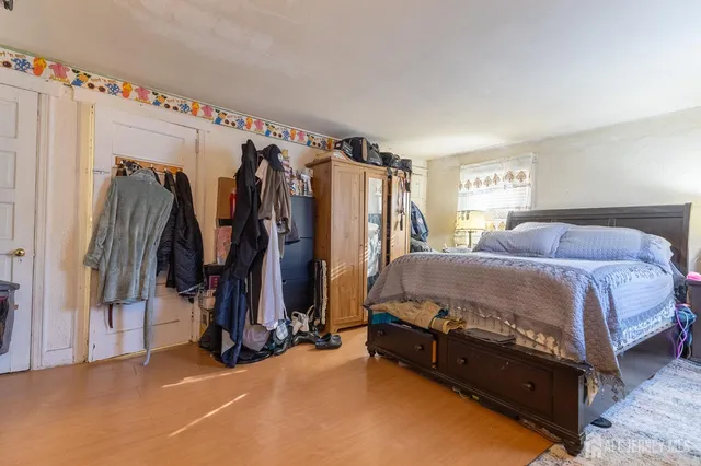 a bed sitting in a spacious bedroom next to a window