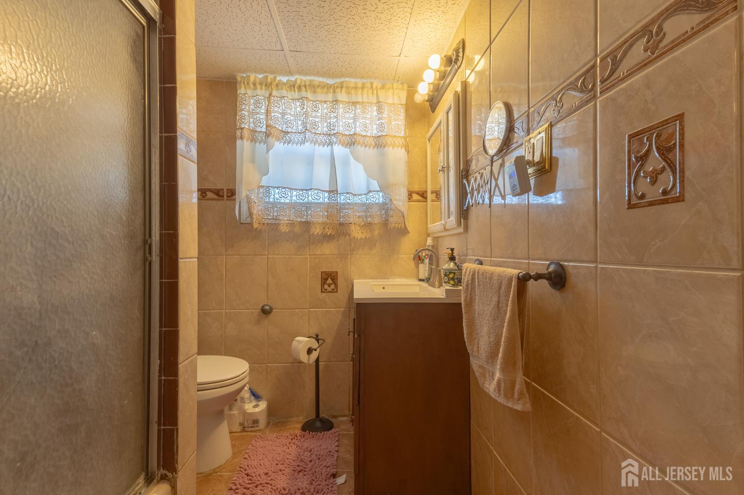 48 Locust Street Carteret, NJ 07008 - Photo 18 of 27 a bathroom with a granite countertop shower a toilet and a sink