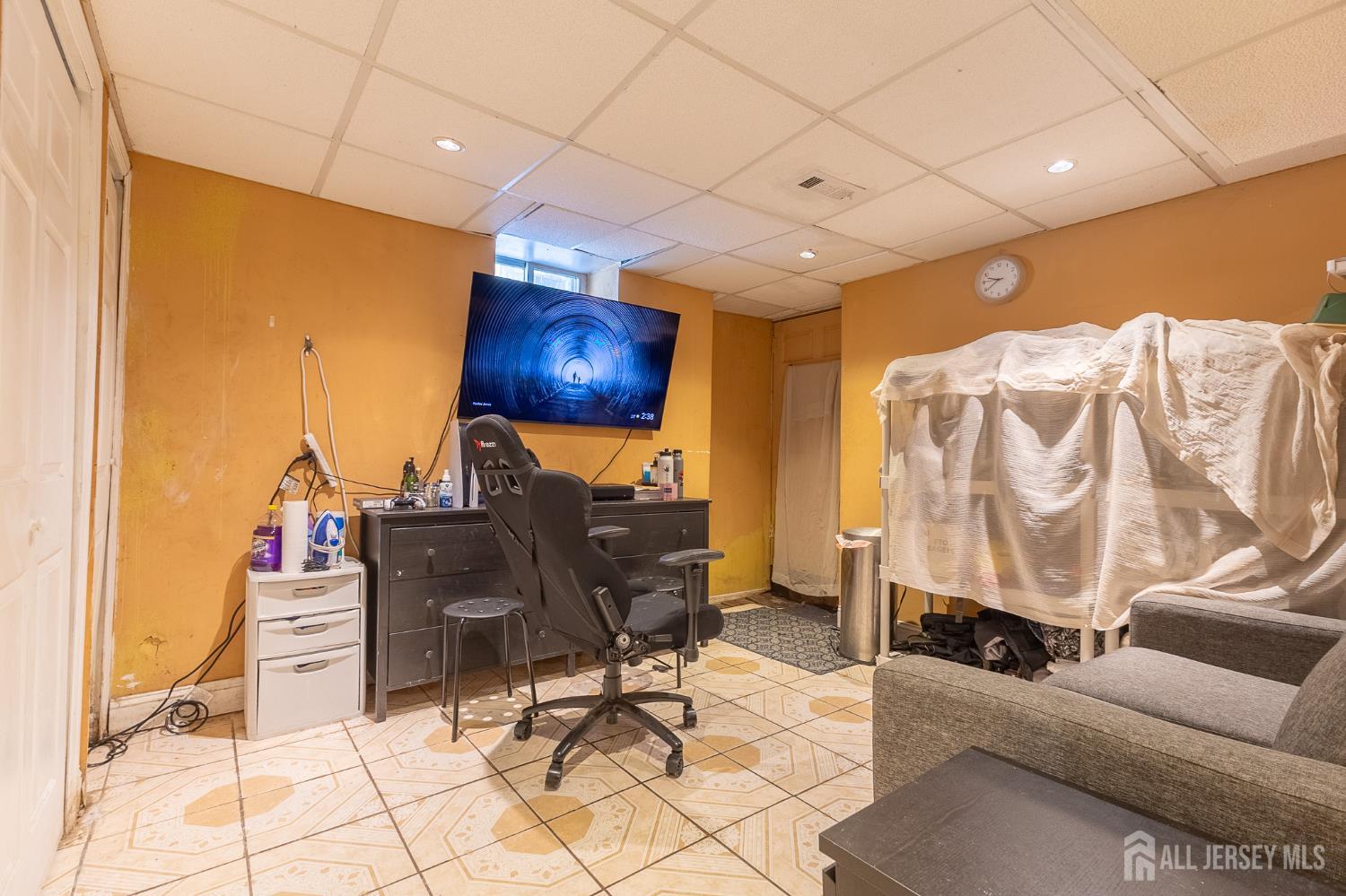 48 Locust Street Carteret, NJ 07008 - Photo 22 of 27 a work room with furniture and a flat screen tv