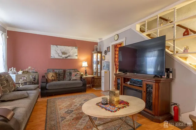 a living room with furniture a window and a flat screen tv