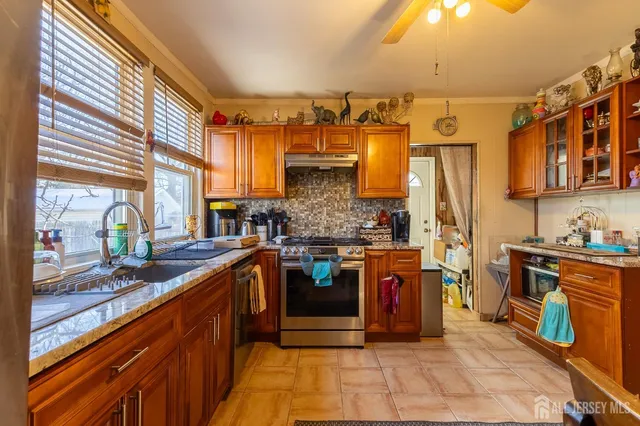 a kitchen with stainless steel appliances granite countertop a stove a sink and a refrigerator