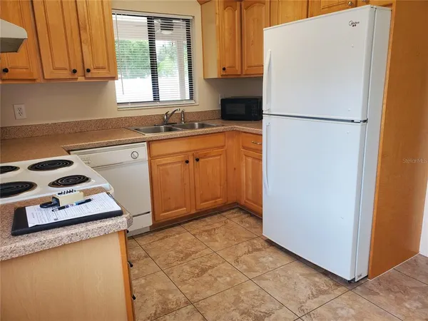 a kitchen with a refrigerator sink and cabinets