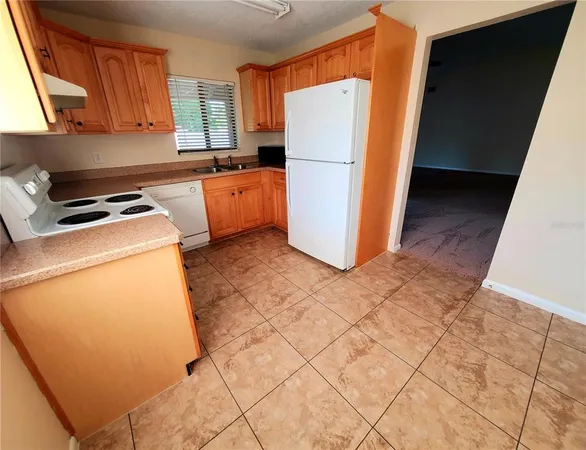 a kitchen with a refrigerator a stove top oven a sink and cabinets