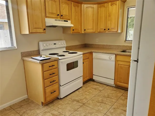 a kitchen with stainless steel appliances granite countertop a stove a sink and a white cabinets