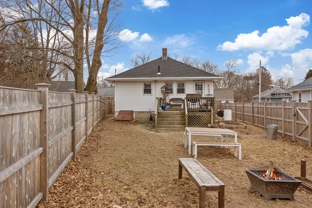 a white building with a yard and a large tree