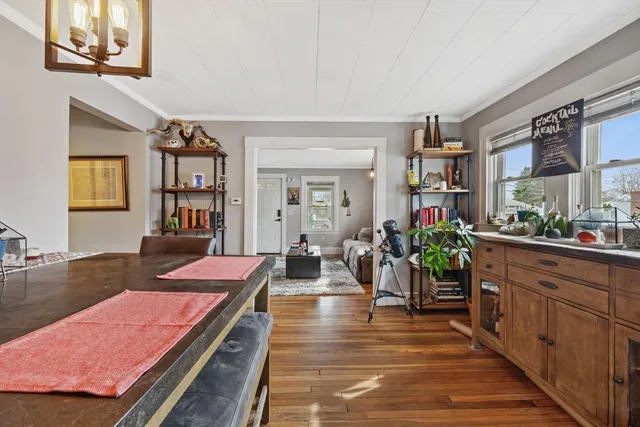 a living room with furniture a chandelier and wooden floor