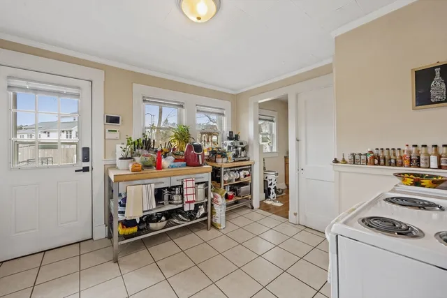 a kitchen that has a lot of white cabinets and stainless steel appliances