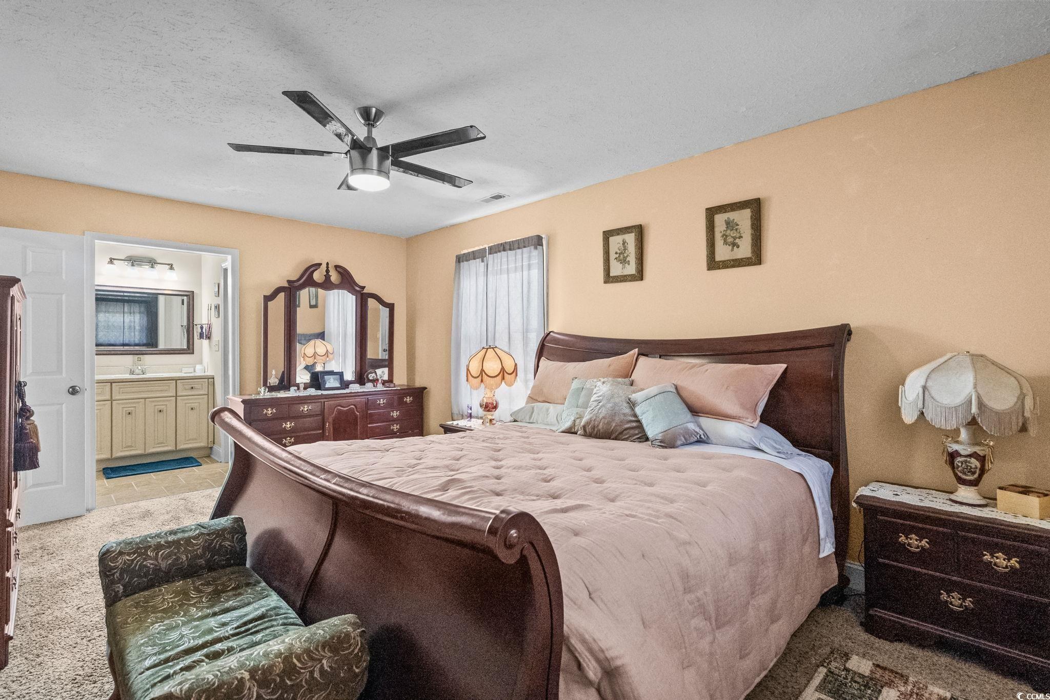 159 Brookgate Drive Myrtle Beach, SC 29579 - Photo 20 of 40 Bedroom with carpet, a textured ceiling, a ceiling fan, and ensuite bathroom
