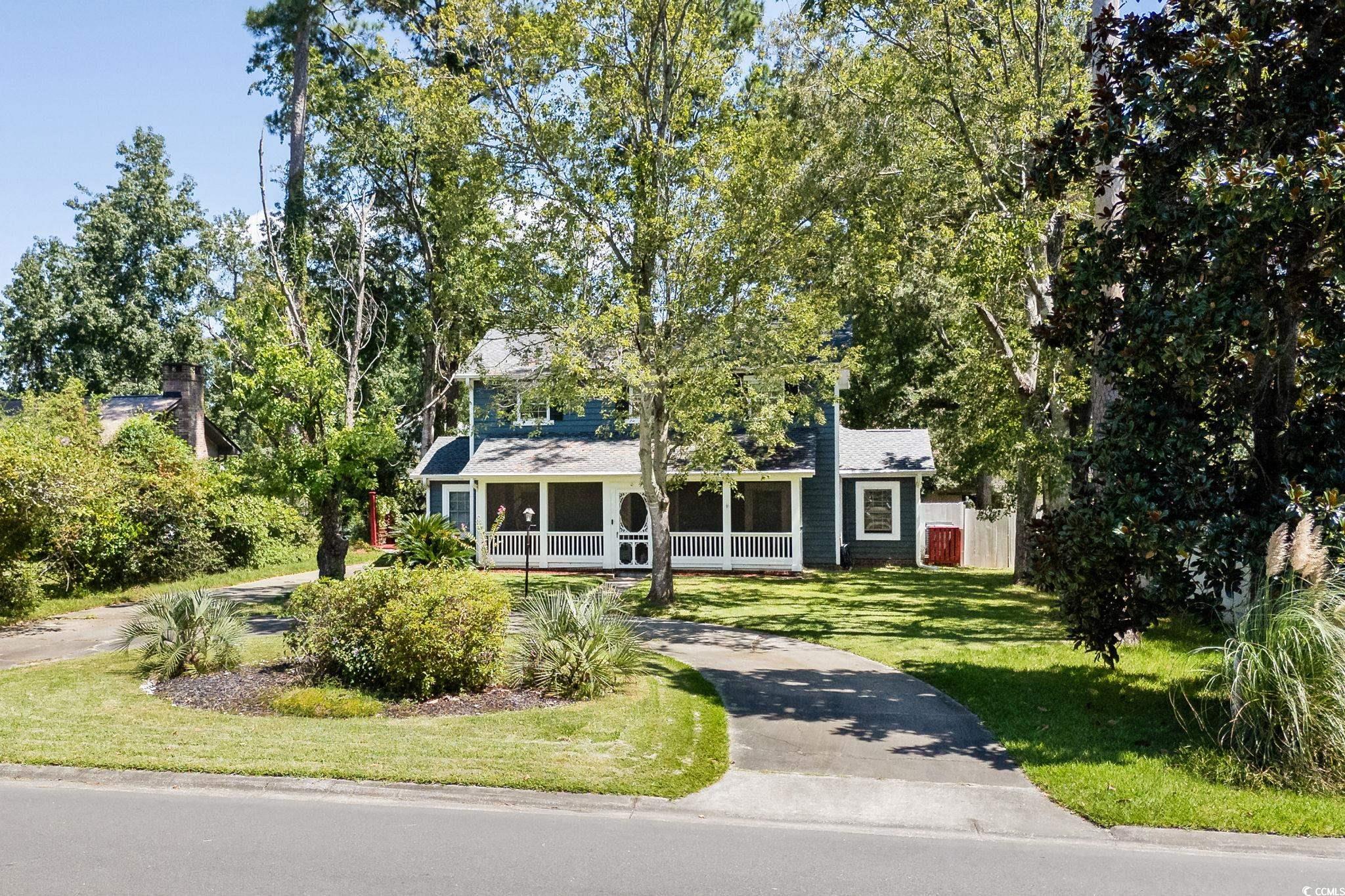159 Brookgate Drive Myrtle Beach, SC 29579 - Photo 34 of 40 View of front of home with a porch, a front yard, view of wooded area, and a shingled roof