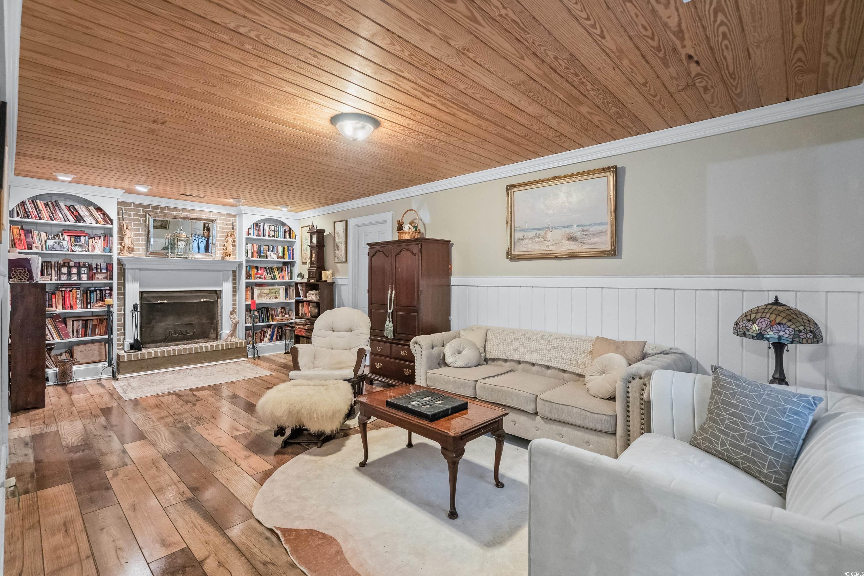 159 Brookgate Drive Myrtle Beach, SC 29579 - Photo 6 of 40 Living area featuring ornamental molding, wood-type flooring, a fireplace, wainscoting, and built in features