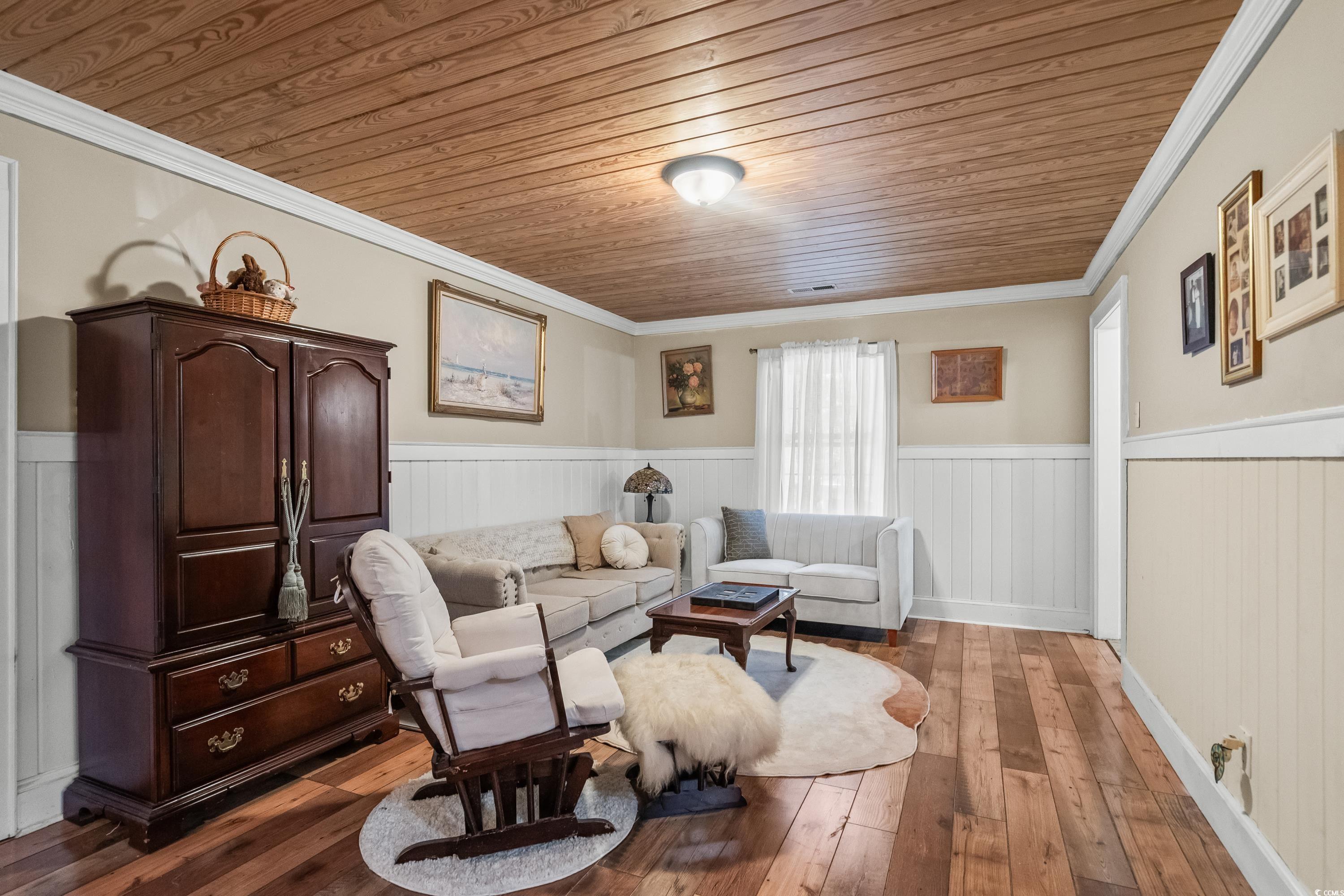 159 Brookgate Drive Myrtle Beach, SC 29579 - Photo 7 of 40 Living area with ornamental molding, wood ceiling, wainscoting, and dark wood-style flooring
