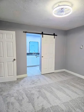 an empty room with a cabinet and mirrors