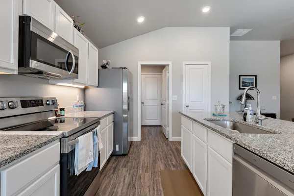 a kitchen with stainless steel appliances granite countertop a stove a sink and a refrigerator