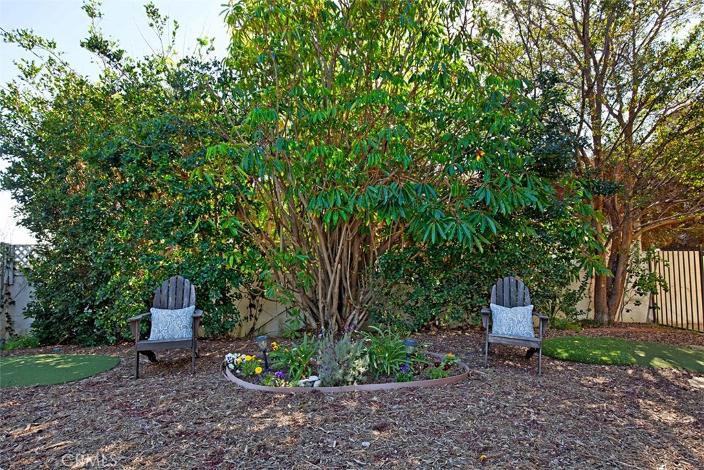 13032 St Thomas Drive North Tustin, CA 92705 - Photo 29 of 32 a wooden bench sitting in the middle of a garden