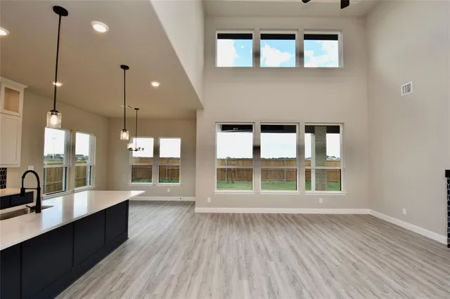 a large empty room with wooden floor and a large window