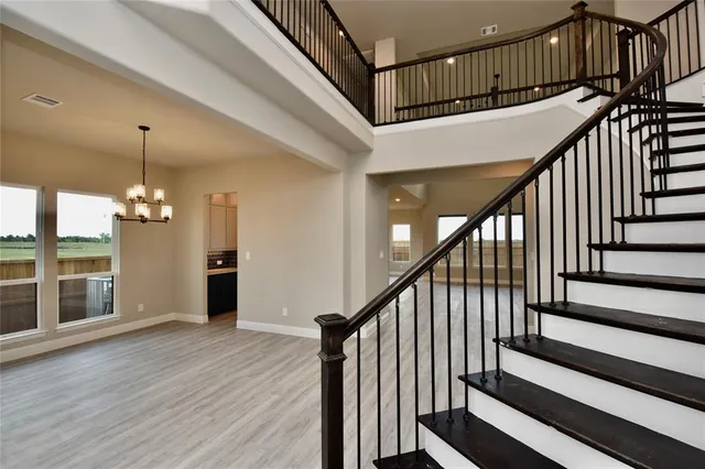 a view of staircase with wooden floor and white walls