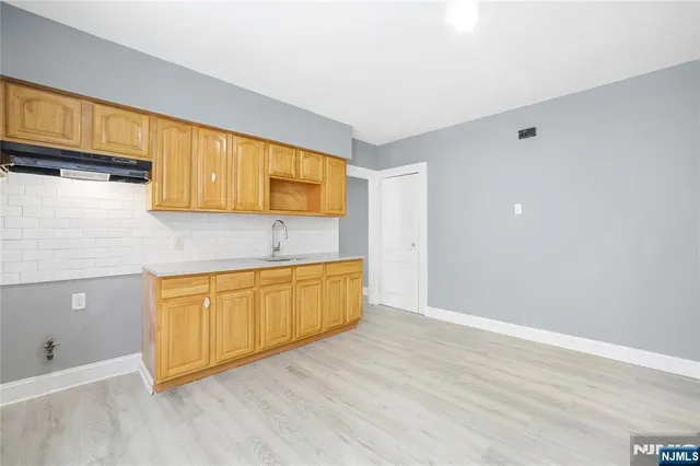 a kitchen with granite countertop wooden cabinets a sink and dishwasher
