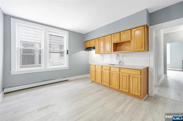 a view of a kitchen with wooden floor and a sink