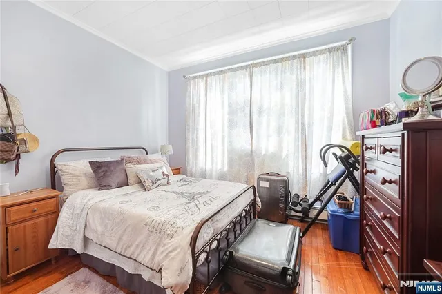 a bedroom with a bed and a flat tv screen on dresser