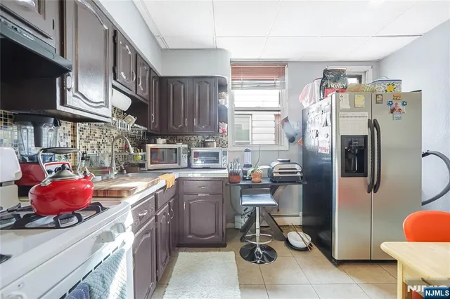 a kitchen with stainless steel appliances a sink cabinets and a window