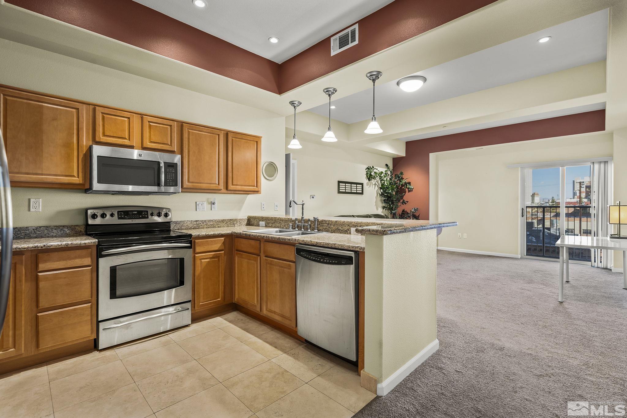 200 West 2nd Street, Unit 202 Reno, NV 89501 - Photo 1 of 18 a kitchen with stainless steel appliances granite countertop a stove top oven a sink and a microwave