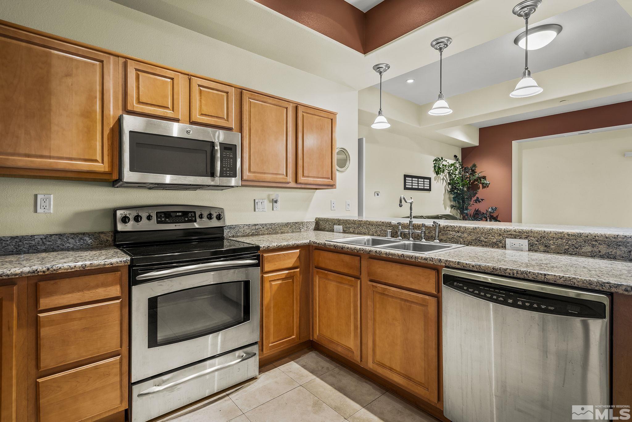 200 West 2nd Street, Unit 202 Reno, NV 89501 - Photo 2 of 18 a kitchen with stainless steel appliances granite countertop wooden cabinets stove top oven and microwave