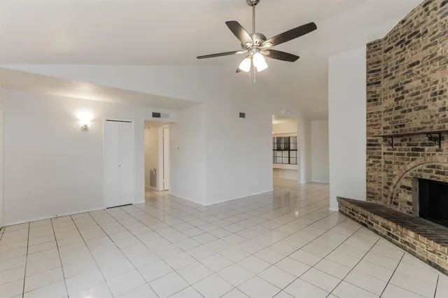an empty room with fireplace and fan