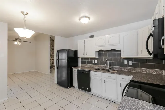 a kitchen with stainless steel appliances granite countertop a sink a stove a refrigerator a washer and dryer