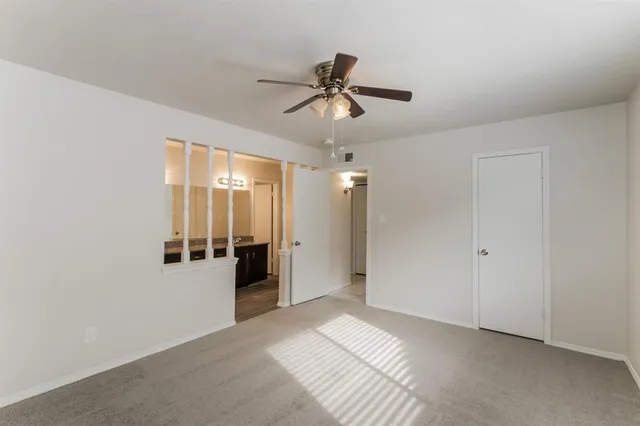 a view of a big room with chandelier fan and windows